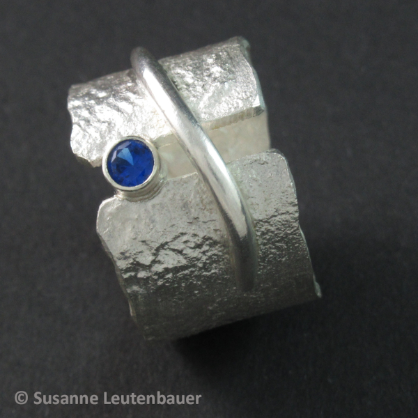 Retikulierter Silberring mit silberner Spange und blauem Zirkonia